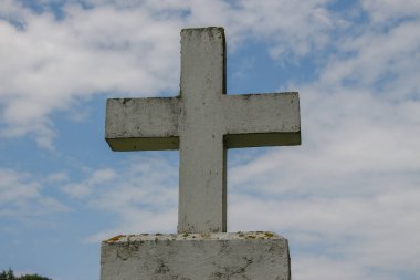 Beyaz çimlerin üzerinde beyaz beton bir Hıristiyan haçı