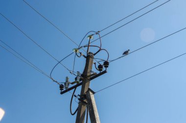Ağustos ayında mavi gökyüzünün arka planında elektrik hatları