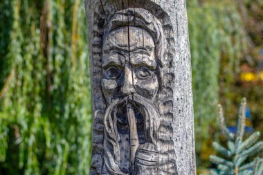 Düşünceli, bıyıklı ve piposu olan Kazak bilgesi ahşap heykeli.