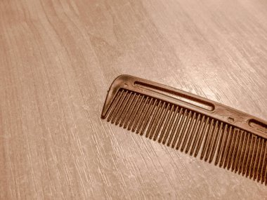 Odadaki masanın üzerinde siyah plastik tarak var.