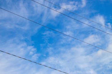 Mavi gökyüzü ve beyaz bulutlar ve elektrik hatları Ağustos 'ta