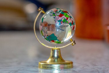 Masanın üzerindeki camdan yapılmış oyuncak küre.
