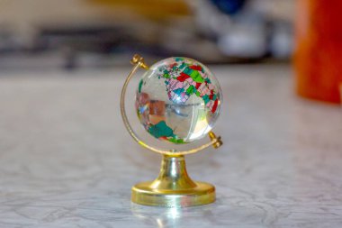 Masanın üzerindeki camdan yapılmış oyuncak küre.