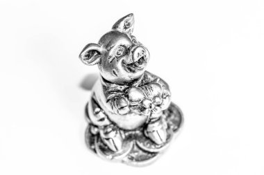 Pençelerinde kalp olan küçük bir domuz heykeli.