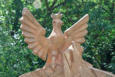 Polonyalı bir kuşun beton heykeli sarıya boyanmış.