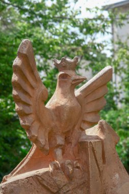 Polonyalı bir kuşun beton heykeli sarıya boyanmış.