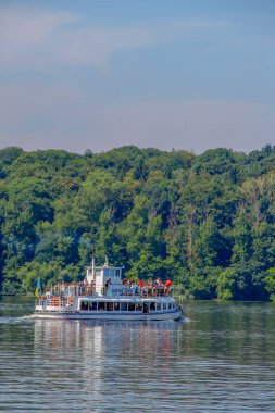 Büyük bir turist gemisi gölette yüzüyor.