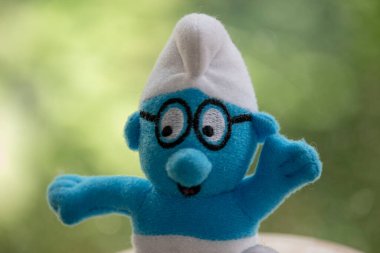 Siyah gözlüklü oyuncak mavi cüce.