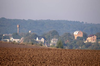 Eylül 'de tarlalar sürüldü ve evler ufukta belirdi