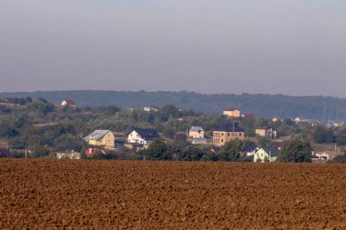 Eylül 'de tarlalar sürüldü ve evler ufukta belirdi