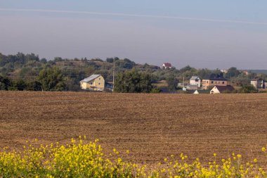 Eylül 'de tarlalar sürüldü ve evler ufukta belirdi