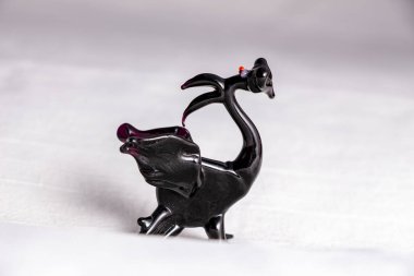 Beyaz arka planda cam siyah ejderha heykeli