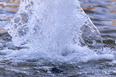 Çeşmeye ve parktaki suya su sıçratır ve fışkırtır.