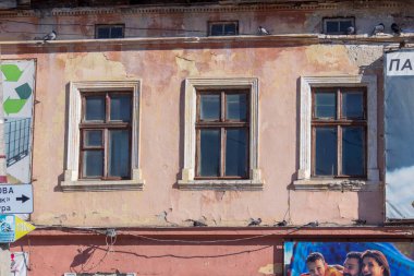 Şehirdeki bir evin ön cephesinde çok pencere var.