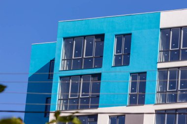 Şehirdeki bir evin ön cephesinde çok pencere var.