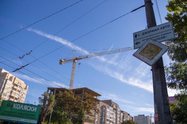 Bir inşaat vinci şehirdeki evlerin inşaatında çalışıyor.