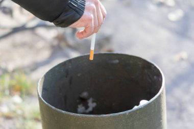 Adam sigarasını çöpe atıyor ve sigarayı bırakmak istiyor.