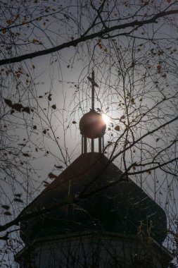 Güneşli bir günde kilisenin çatısının silueti ve haç.