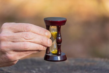 Hayatın kısa olduğunu anlayan yaşlı bir adamın elinde kum saati.