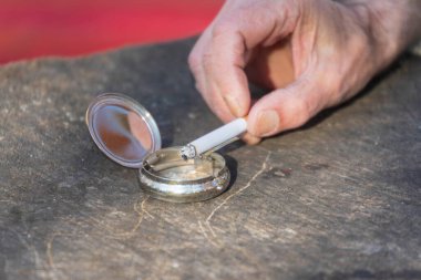 Sigara kültablasında yatıyor.