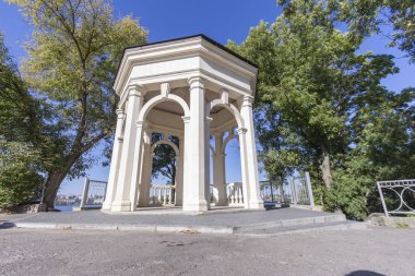 Gölün üzerindeki aşıklar için parkta taş bir çardak.