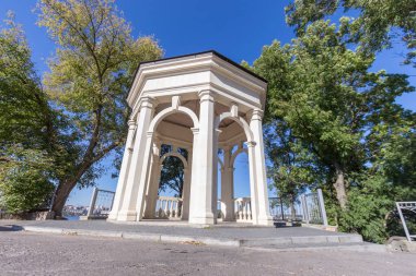 Gölün üzerindeki aşıklar için parkta taş bir çardak.