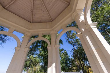 Gölün üzerindeki aşıklar için parkta taş bir çardak.