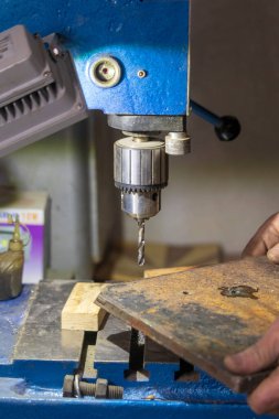 Delme makinesi çalışıyor. Usta atölyede atölye çalışması yapar.