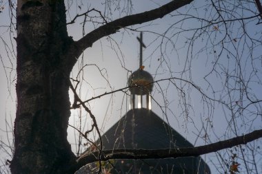 Güneşli bir günde kilisenin çatısının silueti ve haç.