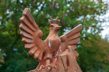 Sonbaharda parkta bir kuşun beton heykeli