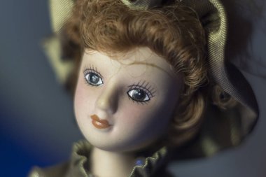 Elbise ve şapka giymiş bir kız şeklinde lüks bir oyuncak bebek.