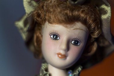 Elbise ve şapka giymiş bir kız şeklinde lüks bir oyuncak bebek.