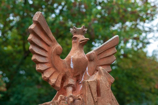 Sonbaharda parkta bir kuşun beton heykeli