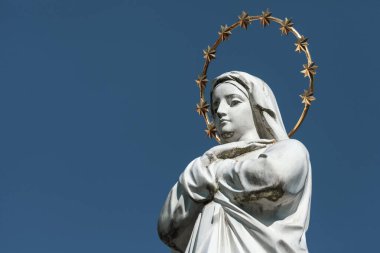 Meryem Ana 'nın heykeli. Altın bir halesi ve kafasında yıldızlar var.