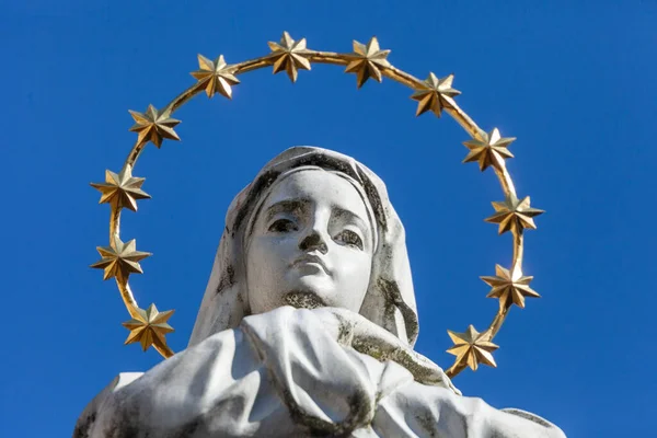 用金光闪闪的光晕和星星在她头上雕刻的圣母像 — 图库照片