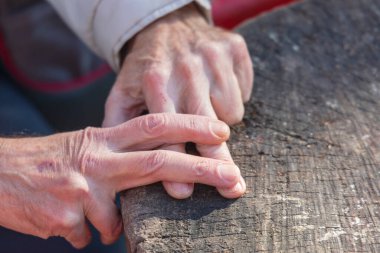Yaşlı bir adam parmaklarını çapraz yapıp hapis taklidi yapıyor.