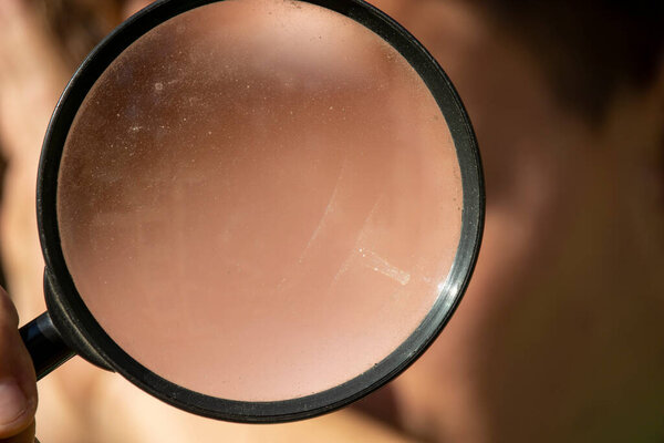 Увеличительное стекло или лупа в руках