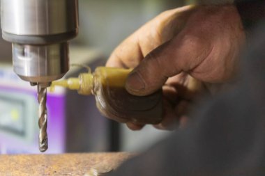 Delme makinesi çalışıyor. Usta atölyede atölye çalışması yapar.