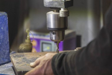 Delme makinesi çalışıyor. Usta atölyede atölye çalışması yapar.