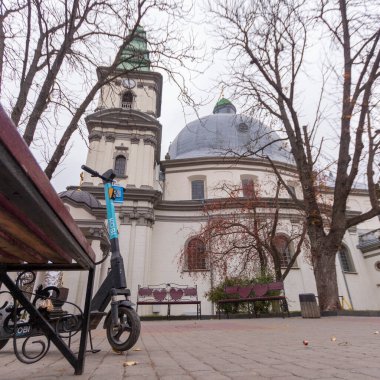 Eski kilisenin çatısı ve kaldırımda bir scooter.
