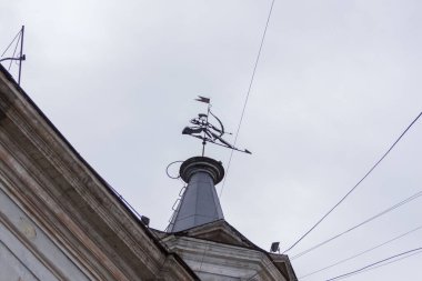 Evin çatısında yay burcu şeklindeki metal rüzgar gülü var.