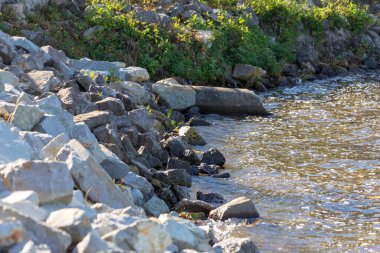 Sonbaharda bir fırtına sırasında göletin kıyısındaki taşlar