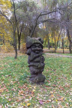 Parktaki tahta bir cüce heykeli Pamuk Prenses ve 7 cüceyle ilgili bir peri masalından