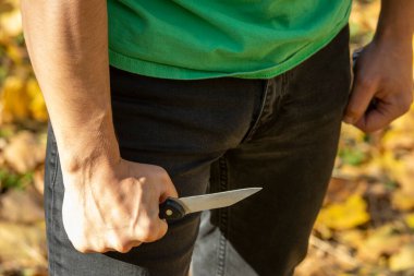 Saldırgan bir adam elinde bıçak tutar ve tehlikelidir.