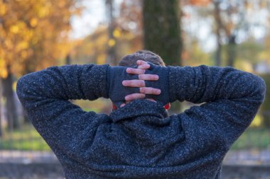 Adam ellerini başının arkasında tutuyor ve tutuklamaya hazırlanıyor.