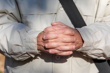 Yaşlı adam Tanrı 'ya dua ediyor ve kollarını kavuşturup dua ediyor.