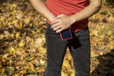 Bir adam cep telefonunu tutar ve aramasını bekler.