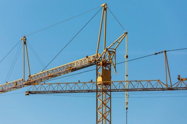Mavi gökyüzünün arka planında sarı metal üreticisi vinç