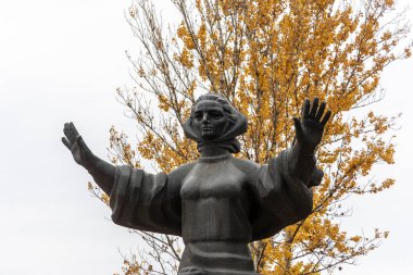 Parktaki annemin anıtı sarı yapraklı bir arka planda.