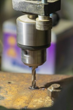 Delme makinesi çalışıyor. Usta atölyede atölye çalışması yapar.